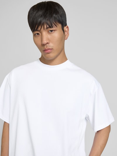 Männermodel trägt Relaxed Fit T-Shirt mit Logo-Stitching von WON HUNDRED in Weiß, reine Baumwolle, Nahaufnahme Oberkörper.