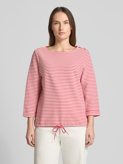 Frauenmodel trägt Regular Fit 3/4-Shirt aus Bio-Baumwoll-Mix von Tom Tailor mit gestreiftem Allover-Muster, Knöpfen am Rundhals, Rippstruktur und Tunnelzug am Saum, Ganzkörperansicht von vorne.