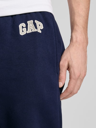 Männermodel trägt Sweatpants mit Logo und elastischem Bund von GAP in Dunkelblau, Baumwoll-Mix, Regular-Fit, Nahaufnahme Oberschenkel.