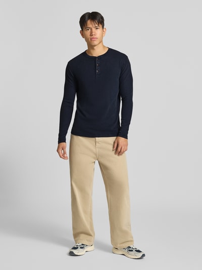 Männermodel trägt Longsleeve mit Strukturmuster und Knopfleiste van Superdry in donkerblauw, puur katoen, regular fit, labelstitching, ronde hals, ruglengte maat M 70 cm, ganzkörperansicht von vorne.
