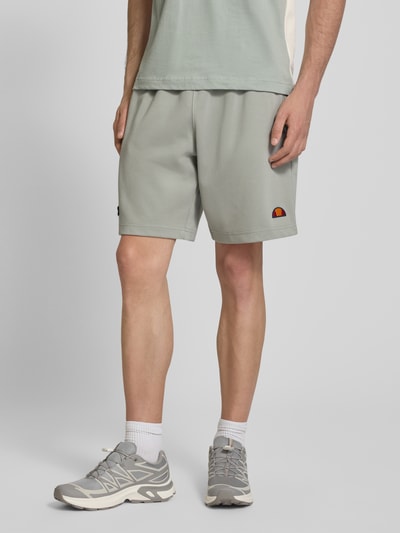 Männermodel trägt Shorts mit Label-Stitchings Modell 'BERTONI' von ellesse in Grau, Relaxed Fit, Baumwoll-Mix, Nahaufnahme Oberschenkel, Kontext Herren Shorts.