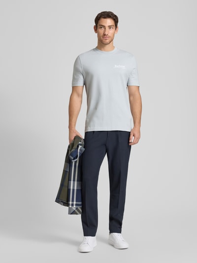 Męski model nosi Relaxed Fit T-Shirt aus reiner Baumwolle Modell 'WILDFELL' od Barbour, jednolity, jasnoszary, z krótkim rękawem, bawełniany jersey, nadrukowane logo, okrągły dekolt, pełen widok z przodu.