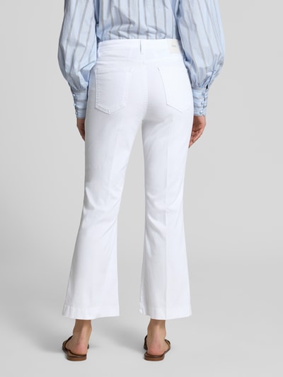 Modelka prezentuje białe Bootcut Jeans im 5-Pocket-Design Modell 'Mary' von Brax z mieszanki bawełny i lyocellu z dodatkiem streczu, fason z poszerzaną nogawką, detal z logo, szerokość w rozmiarze 36: 39 cm, długość wewnętrzna nogawki 67 cm, widok całej sylwetki od tyłu.