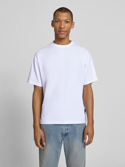 Męski model nosi Regular Fit T-Shirt aus Baumwoll-Mix Modell 'GEZA-R' od Strellson, biała gładka powierzchnia, krótki rękaw, okrągły dekolt, krój regular fit, widok całej sylwetki z przodu.