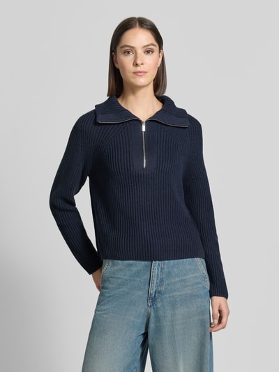Frauenmodel trägt Regular Fit Troyer aus Baumwoll-Mix von Oui in Dunkelblau, feine Strickstruktur, Troyer-Kragen mit Reißverschluss, Ganzkörperansicht von vorne.