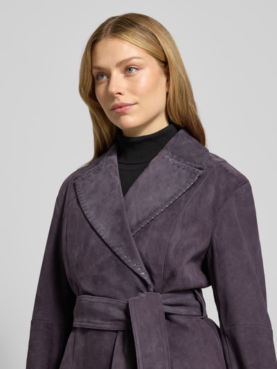Vrouwenmodel draagt Lederjacke mit Bindegürtel van Marc Cain, echt leer, getailleerd, reverskraag, ceintuur, close-up bovenlichaam.