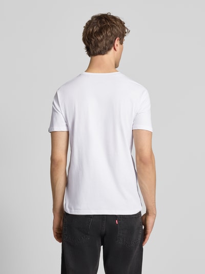 Männermodel trägt T-Shirt aus Baumwolle von Alpha Industries in Weiß, Gerader-Schnitt, Label-Print-Details, Rückenlänge 68 cm, Ganzkörperansicht Rückansicht.