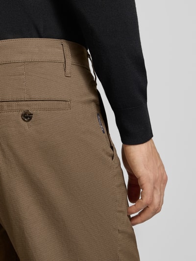 Männermodel trägt Straight Fit Stoffhose aus Baumwoll-Mix von Christian Berg Men in Braun mit Strukturmuster, Nahaufnahme Hüfte, KI-modifiziertes Bild.