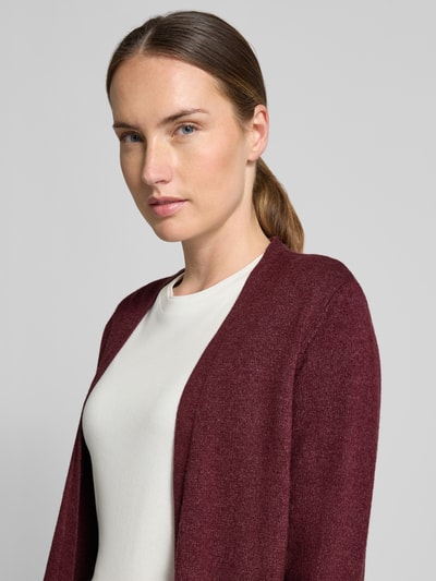 Frauenmodel trägt Strickjacke aus Viskose-Mix von VILA in Dunkelrot, taillierte Passform, glatte Textur, Nahaufnahme Oberkörper.