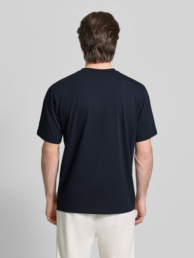 Männermodel trägt Regular Fit T-Shirt aus Baumwoll-Mix Modell 'ICONIC' von BOSS Green in Dunkelblau, unifarben, Ganzkörperansicht Rückansicht.