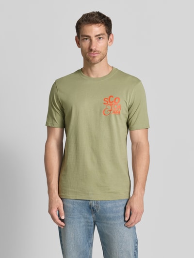 Männermodel trägt Regular Fit T-Shirt mit Logo-Print von Scotch & Soda in Grün, reine Baumwolle, Rundhalsausschnitt, Ganzkörperansicht von vorne.