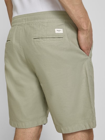 Männermodel trägt Relaxed Fit Chinoshorts aus Baumwoll-Leinen-Mix von Pepe Jeans, Optik: Unifarben, Label-Patch, Paspeltaschen, Ganzkörperansicht Rückansicht.
