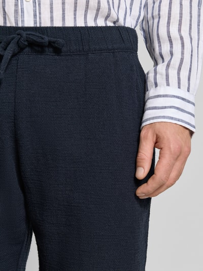 Männermodel trägt Shorts mit elastischem Bund und Tunnelzug von MCNEAL aus Baumwoll-Mix, Regular-Fit, Nahaufnahme Oberkörper.