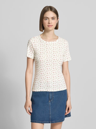Frauenmodel trägt Damen T-Shirt von Pieces, Modell 'Slim Fit T-Shirt aus reiner Baumwolle Modell 'TURIEL'', Optik:Allover-Muster, Slim-Fit, Rundhals mit Rüschen, Ärmelform: Kurzarm, Materialverarbeitung: Ripp, Material: Reine Baumwolle, helle Grundfarbe mit kleinen bunten Mustern, Ganzkörperansicht von vorne.