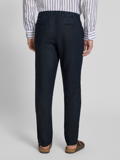 Männermodel trägt dunkelblaue Leinenhose mit Eingrifftaschen Modell 'Pandrup' von Casual Friday, reine Leinenstruktur, Ganzkörperansicht Rückansicht.