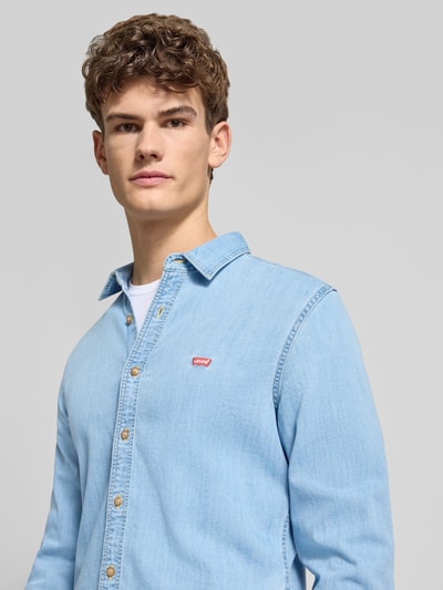 Männermodel trägt Freizeithemd in Denim-Optik von Levi's®, hellblaue Farbe, Baumwoll-Mix mit Stretch-Anteil, Nahaufnahme Oberkörper.