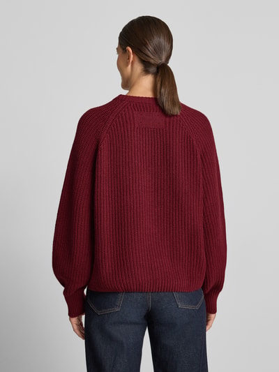 Frauenmodel trägt Loose Fit Pullover aus Woll-Mix Modell 'RIB KNIT' von ARMEDANGELS in Dunkelrot, strukturierte Oberfläche, Ganzkörperansicht Rückansicht.