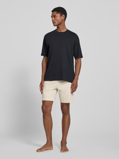 Männermodel trägt Regular Fit Sweatshorts aus Baumwoll-Mix Modell 'MIX&MATCH' von BOSS in Beige, dezente Struktur, Ganzkörperansicht von vorne, Herren Sweatshorts von BOSS.