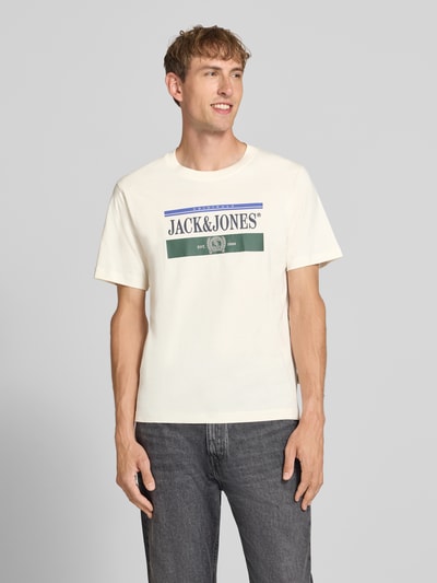 Męski model nosi męski t-shirt z bawełny prosty krój model 'FREDERIKSBERG' z okrągłym dekoltem nadruk z logo, długość tyłu w rozmiarze M: 70 cm, JACK & JONES, widok całej sylwetki z przodu