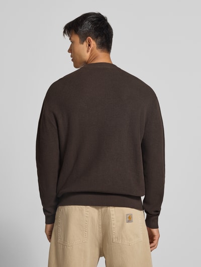 Männermodel trägt Regular Fit Strickpullover aus reiner Baumwolle von REVIEW in Dunkelbraun, Struktur mit Rundhalsausschnitt, Ganzkörperansicht Rückansicht.