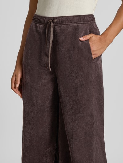 Frauenmodel trägt Barrel Jeans mit Tunnelzug Modell 'Misha barrel' von OPUS in dunklem Braun mit Cordstruktur, Nahaufnahme Oberkörper, Damen Barrel Jeans von OPUS.