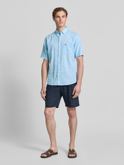 Männermodel trägt Slim Fit Freizeithemd aus leinen-baumwoll-mix van Fynch-Hatton in lichtblauw, borstzak, button-downkraag, labelstitching, knoopsluiting, ruglengte maat M 74 cm, schouderbreedte 48 cm, mouwlengte 26 cm, ganzkörperansicht van voren.