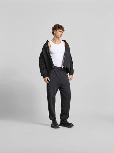 Männermodel trägt weißes Tanktop mit Label-Stitching von Diesel aus Baumwoll-Elasthan-Mix, Slim Fit, Ganzkörperansicht von vorne.