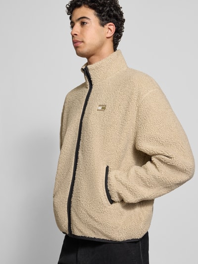 Männermodel trägt Relaxed Fit Fleecejacke in Teddyfleece-Optik von Tommy Jeans, Optik: Unifarben, Passform: Relaxed-Fit, Stehkragen, Reißverschluss, Label-Stitching, Logo-Detail, Langarm, elastischer Ärmel- und Rumpfabschluss, seitliche Eingrifftaschen, Materialverarbeitung: Webkunstfell, Beige, weiche Struktur, Ganzkörperansicht von vorne.