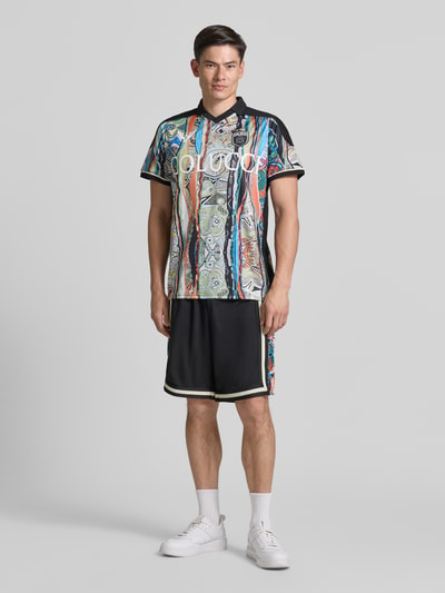 Männermodel trägt Slim Fit T-Shirt mit Label-Print von COLUCCI, bunt gemustert, Polokragen, glatte Textur, Ganzkörperansicht von vorne.