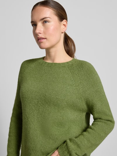 Vrouwenmodel draagt Regular Fit pullover uit alpacamix model 'GHIACCI' van Weekend Max Mara in olijfgroen, grove textuur, Nahaufnahme bovenlichaam.