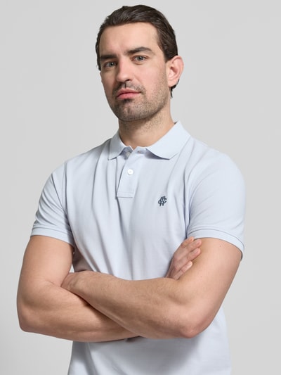 Männermodel trägt Slim Fit Poloshirt mit Logo-Stitching von MCNEAL, reine Baumwolle, Polokragen, helles Uni-Design, Nahaufnahme Oberkörper.