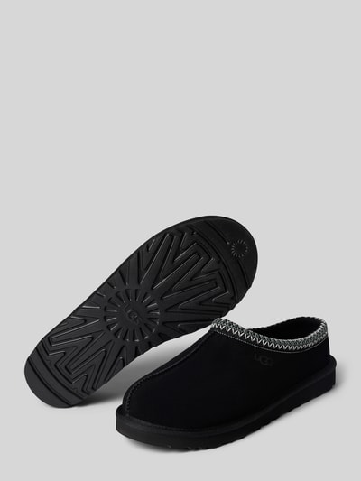 Produktfoto, schwarze Hausschuhe aus Leder Modell 'TASMAN II' von UGG, abgerundete Spitze, markante Sohle, strukturierte Textur