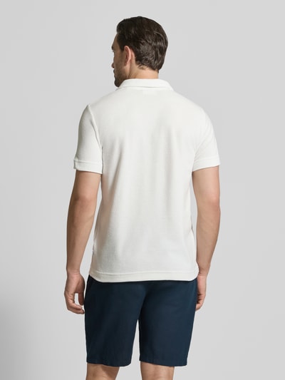 Männermodel trägt Relaxed Fit Poloshirt mit V-Ausschnitt von Lindbergh aus Baumwoll-Mix in Frottee mit Brusttasche, Rückenlänge 76 cm, Ganzkörperansicht Rückansicht.