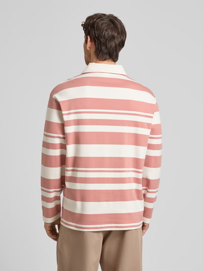 Mężczyzna model nosi koszulkę polo Relaxed Fit Poloshirt aus reiner Bio-Baumwolle Modell 'JACK' von SELECTED HOMME, efekt: wzór na całej powierzchni, wyhaftowane logo, kołnierzyk polo, zapięcie na 2 guziki, długi rękaw, dzianina dresowa, bawełna ekologiczna, tył w jasnoróżowe i kremowe pasy, całkowity widok z tyłu.