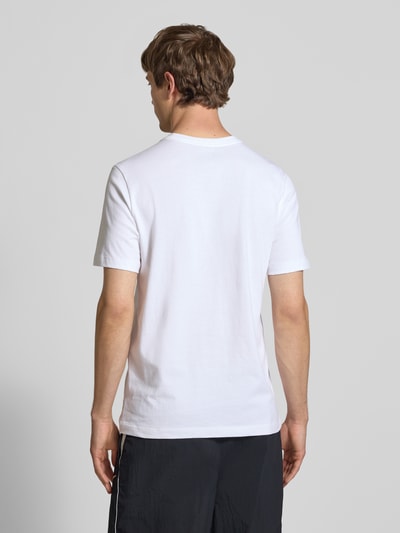 Männermodel trägt Herren T-Shirt mit Label-Stitching von Nike, weiße Reine Baumwolle, Regular-Fit, Rundhalsausschnitt, Rückenlänge 73 cm, Ganzkörperansicht Rückansicht.