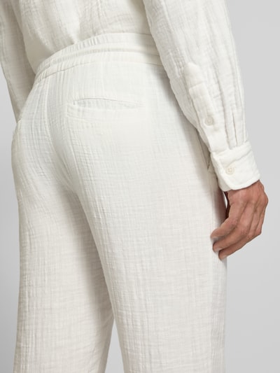 Männermodel trägt Straight Fit Sweatpants in Musselin-Optik von Lindbergh aus Reine Baumwolle in Weiß, Detailaufnahme Rückansicht.