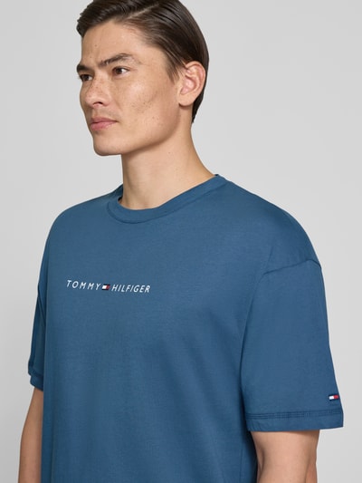 Männermodel trägt Regular Fit T-Shirt mit Label-Schriftzug aus reiner Baumwolle von Tommy Hilfiger, unifarben, Nahaufnahme Oberkörper.