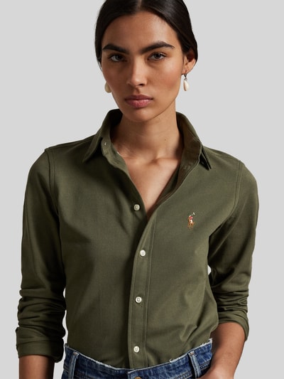Frauenmodel trägt Hemdbluse mit Label-Stitching von Polo Ralph Lauren in Olivgrün, reine Baumwolle, Button-Down-Kragen, Nahaufnahme Oberkörper.