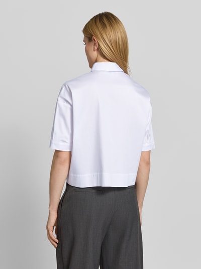 Frauenmodel trägt weiße Hemdbluse mit Brusttasche und Kentkragen von More & More aus Baumwoll-Mix mit Stretch-Anteil, Regular-Fit, Ganzkörperansicht Rückansicht.