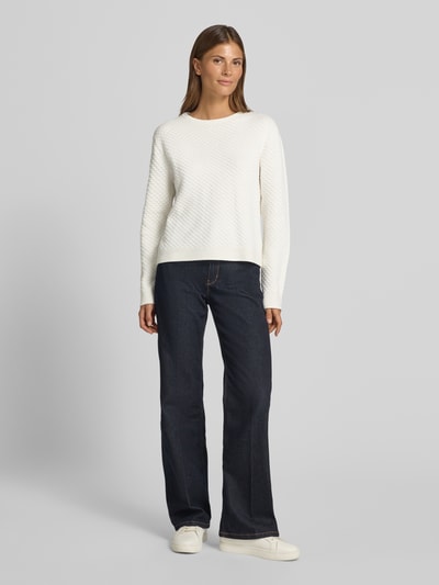 Frauenmodel trägt Regular Fit Pullover aus reiner Baumwolle von Tom Tailor, cremeweiß, strukturierte Oberfläche, kombiniert mit dunklen Jeans, Ganzkörperansicht von vorne, Damen Pullover von Tom Tailor.
