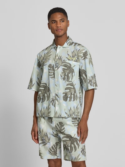 Männermodel trägt Relaxed Freizeithemd mit floralem Allover-Print von Lindbergh in Grün und Beige, elastischer Baumwoll-Mix, Ganzkörperansicht von vorne.