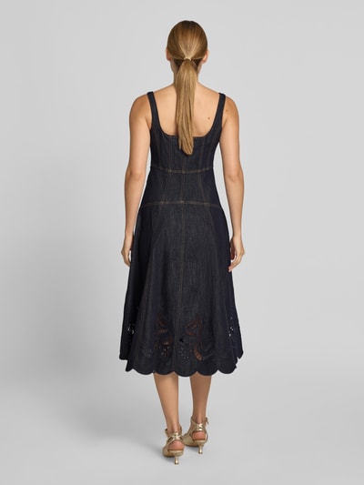 Frauenmodel trägt Knielanges Kleid in Denim-Optik von Self-Portrait im Baumwoll-Mix, taillierte Passform, Loch-Stickereien, Knielänge, ärmelloses-Design, Reißverschluss; dunkle Denimfarbe, strukturierte Oberfläche, Gesamtlänge 98 cm, Brustweite 43 cm, Taillenweite 38 cm, Ganzkörperansicht Rückansicht.