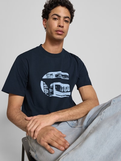 Männermodel trägt Regular Fit T-Shirt mit Logo-Print Modell 'icon' von G-Star Raw, dunkelblau, reine Baumwolle, Nahaufnahme Oberkörper.