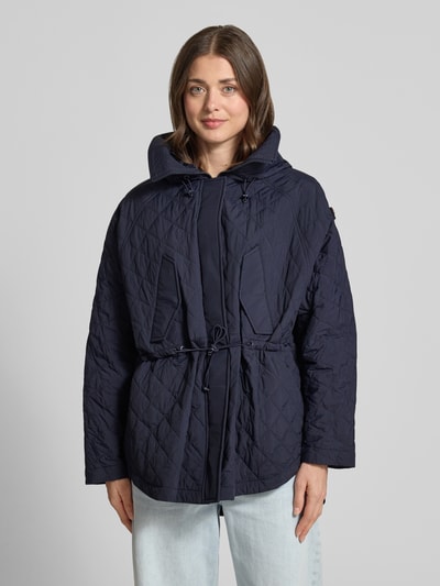 Frauenmodel trägt Relaxed Fit Jacke in Stepp-Optik Modell 'Texel' von Peuterey in Dunkelblau mit Stehkragen und Pattentaschen, Ganzkörperansicht von vorne.