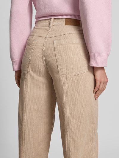 Frauenmodel trägt Straight Fit Cordhose mit Logo-Patch von BAUM & PFERDGARTEN aus beigem Cord, Gesäßtaschen, Rückansicht Nahaufnahme.