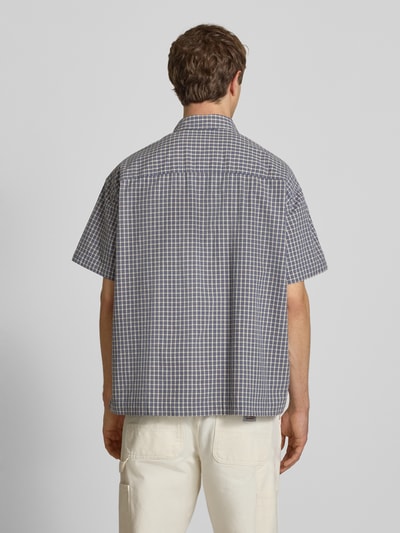 Männermodel trägt Loose Fit Freizeithemd aus reiner Baumwolle Modell 'DAVES' von Only & Sons mit kariertem Allover-Muster, Ganzkörperansicht Rückansicht.