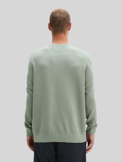 Männermodel trägt hellgrünen Regular Fit Pullover aus reiner Baumwolle von Marc O'Polo, strukturierte Oberfläche, Ganzkörperansicht Rückansicht.