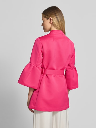 Frauenmodel trägt Blazer mit ausgestellten Ärmelabschlüssen von Marc Cain in Pink, Stehkragen, Taillierte Passform, Stoffband, 3/4-Arm, Rückenlänge 82 cm, Brustweite 52 cm, Ärmellänge 49 cm, Ganzkörperansicht Rückansicht