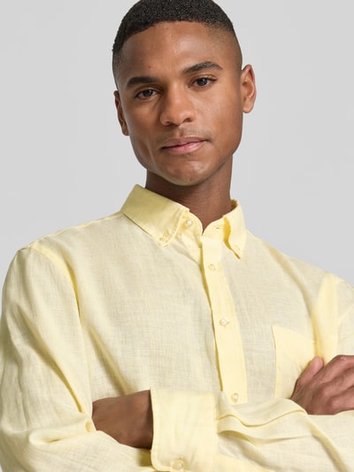 Männermodel trägt Slim Fit Leinenhemd mit Brusttasche von Christian Berg Men in Gelb, Button-Down-Kragen, Knopfleiste, Nahaufnahme Oberkörper.