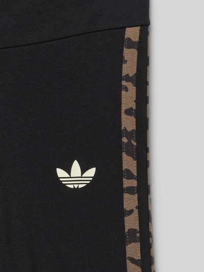 Productfoto, Leggings met logo-print en elastische tailleband van adidas Originals in zwart met bruin patroon, katoenmix met stretch, aansluitende fit, detailopname.